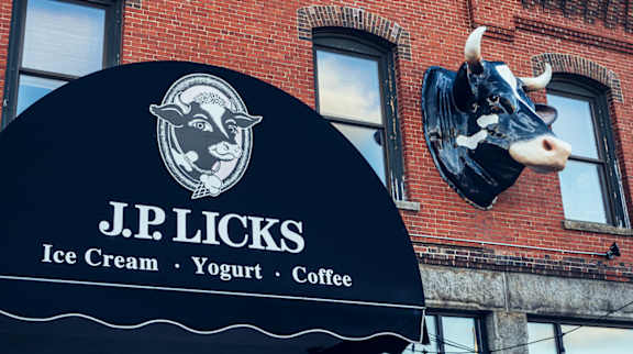 A black sign with a cow head and the words J.P. Licks Ice Cream, Yogurt, Coffee.
