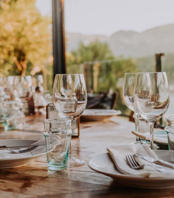 a wooden table with plates and wine glasses on it