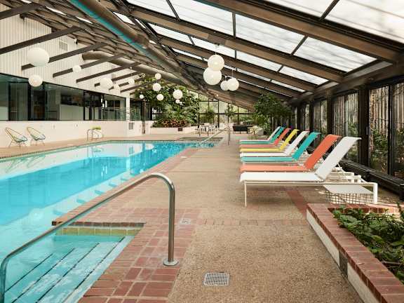 A pool with a metal railing and a glass ceiling.