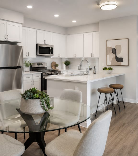 A well-lit, modern kitchen and living room with a dining area.
