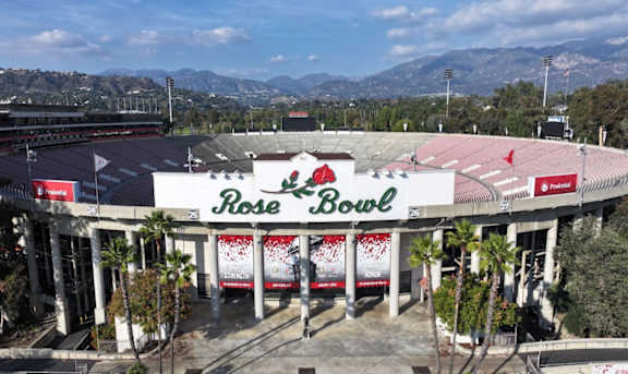 Rose Bowl stadium in the distance with trees in the foreground.