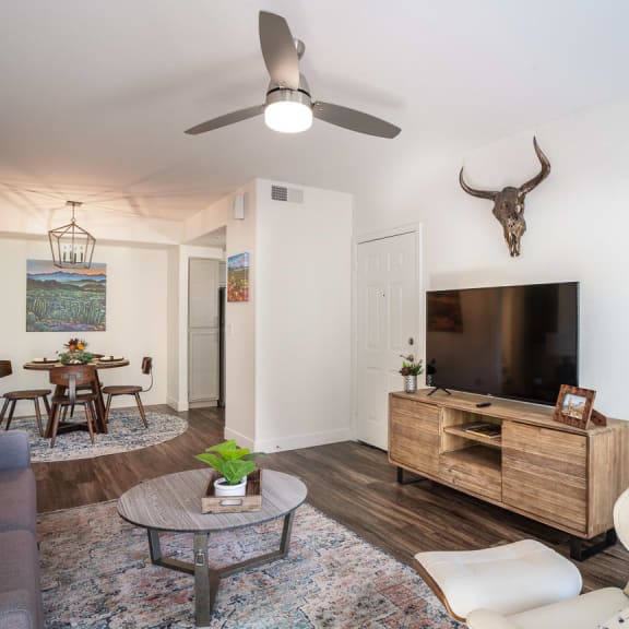 a living room with a large tv and a dining room table in the background