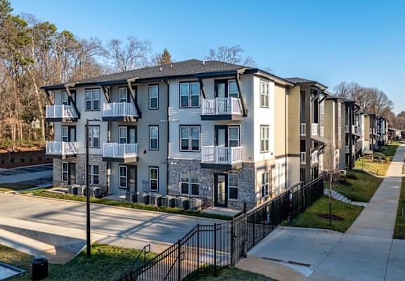 Apartment complex with a black fence in front.