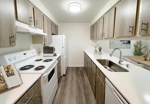 a kitchen with white appliances and wooden cabinets