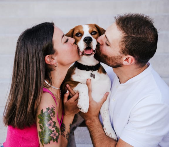 a man and a woman kissing a dog