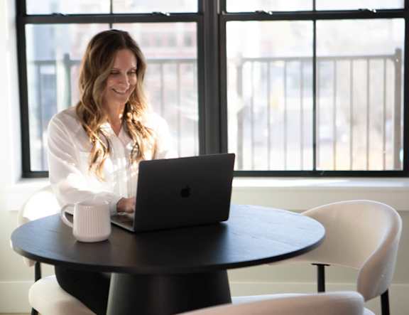 A woman is working on her laptop at The Pearl, Fort Wayne, 46802