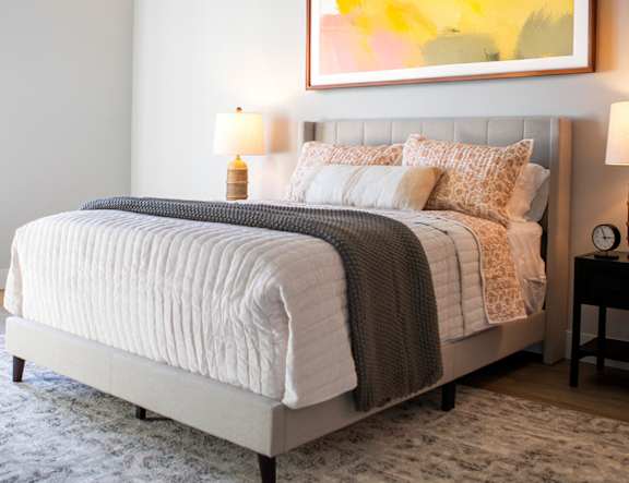 A bed with a white comforter and pillows at The Pearl, Fort Wayne, 46802