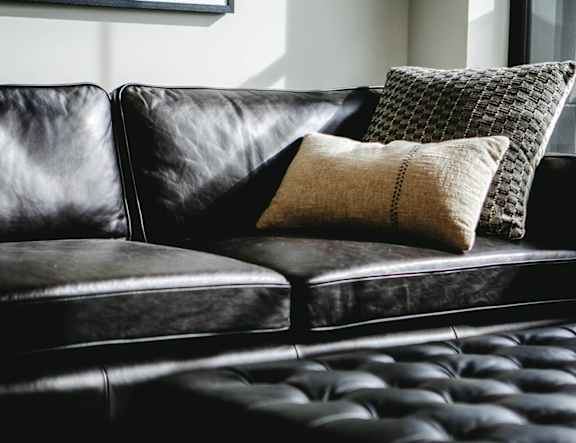 A black leather couch with two pillows on it at The Pearl, Fort Wayne, 46802