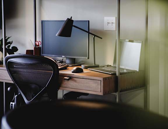 A black chair is in front of a desk with a computer monitor at The Pearl, Fort Wayne, 46802