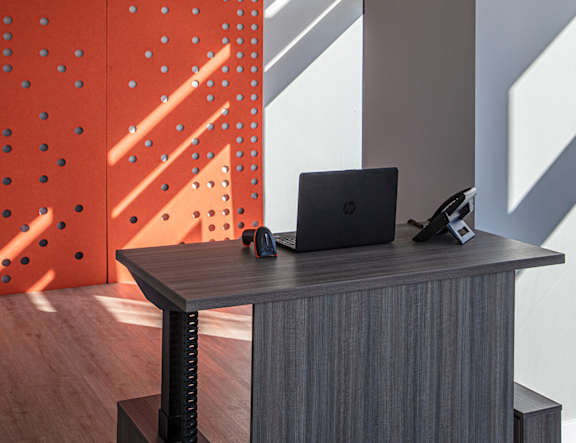 A black laptop is on a desk with a black mouse and a black phone at The Pearl, Fort Wayne, 46802
