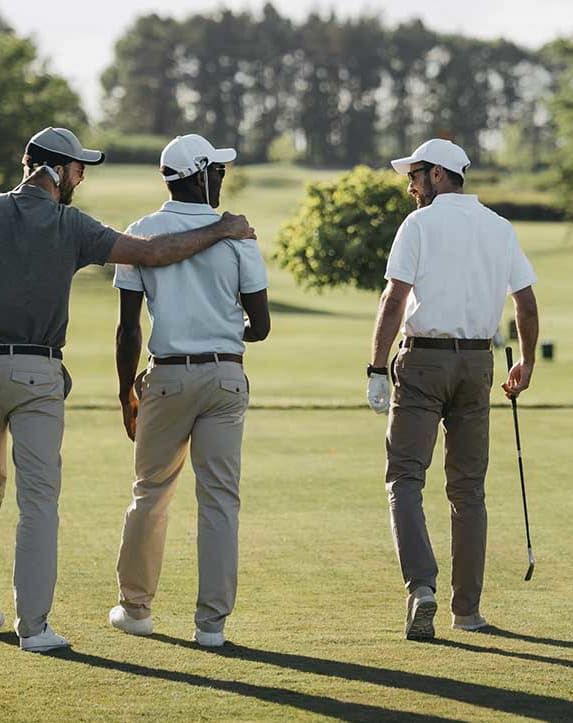 three men walking on a golf course together