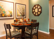 Thumbnail 31 of 55 - a dining room with a table and chairs and paintings on the wall