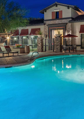 a swimming pool with chaise lounge chairs and umbrellas in front of a hotel