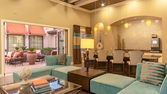 a living room with blue couches and a table with chairs
