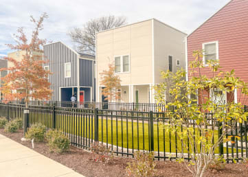a row of houses with a sidewalk in front of them