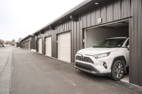 a white 2020 rav4 parked in front of a garage door