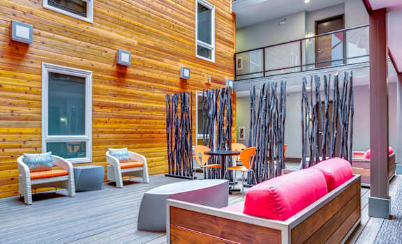 a room with a couch and chairs on a wooden deck