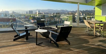 A patio with a table and chairs overlooking a cityscape.