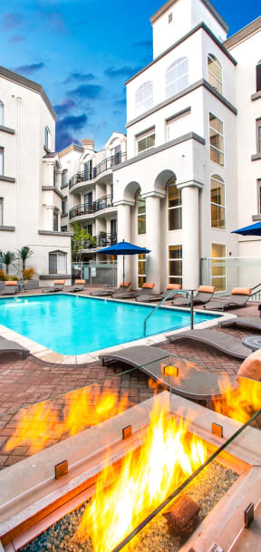 Sparkling Pool with Sun Lounge Chairs and Nearby Firepit at The Preston Miracle Mile Apartments, Los Angeles, CA, California, 90036