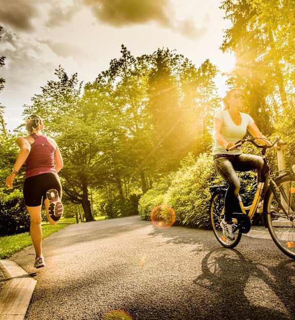 two women riding bikes down a road