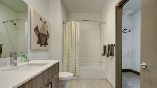 Kansas City MO Apartments-The Grand Apartments Bathroom With White Countertop And Square Tile And Neighboring Closet