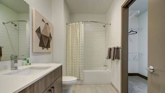 Kansas City MO Apartments-The Grand Apartments Bathroom With White Countertop And Square Tile And Neighboring Closet  at The Grand, Kansas City, MO