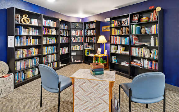 A room with a purple wall and a bookshelf filled with books.