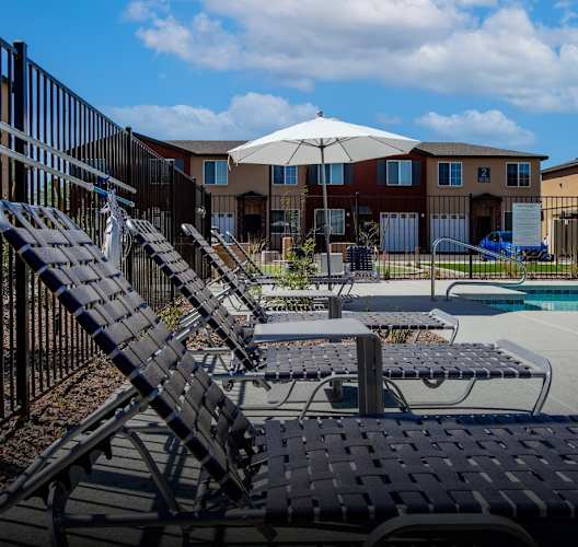 our apartments have a large pool with lounge chairs and an umbrella