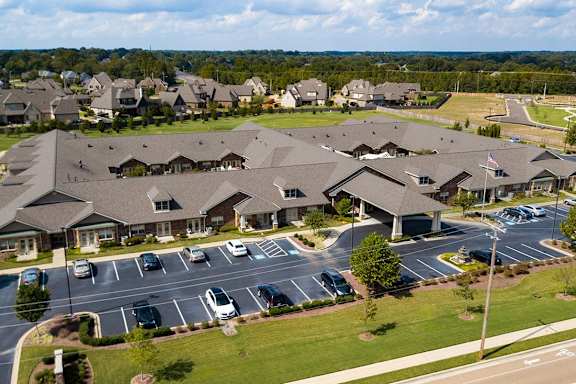A large building complex with a parking lot in front.