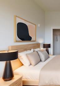 A bedroom with a large bed and two nightstands.