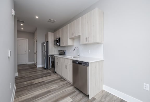 A modern kitchen with wooden cabinets and stainless steel appliances.
