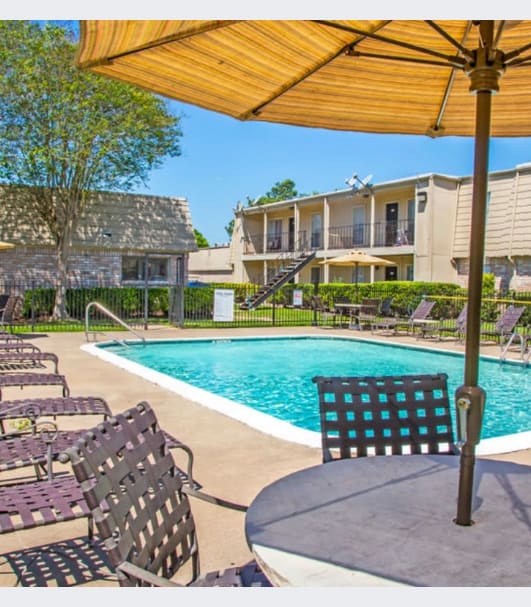 a swimming pool with chairs and an umbrella