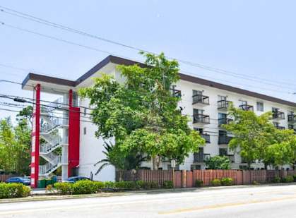 a large white building with trees in front of it