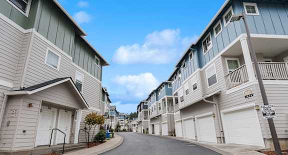 A row of houses with garages on the side.
