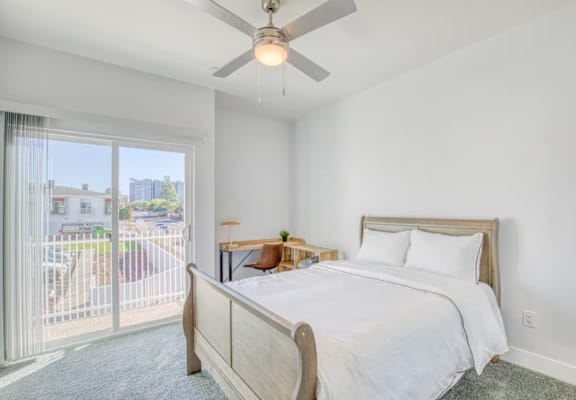 A bedroom with a large bed and a ceiling fan.