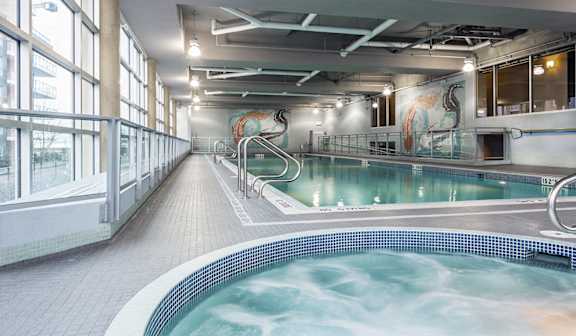 A large indoor swimming pool with a mural on the wall.