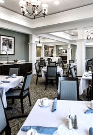 a dining room with tables and chairs and a bar at Arbor Hills, Florida, 33805