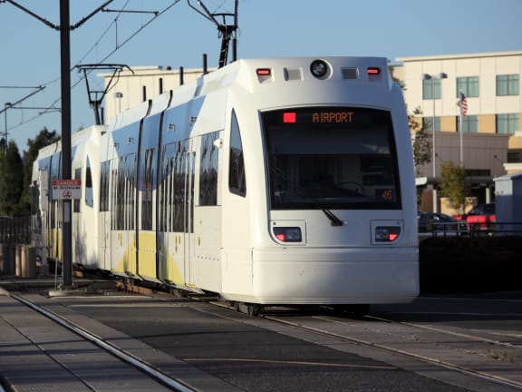 a TriMet max train on a track with blue sky background