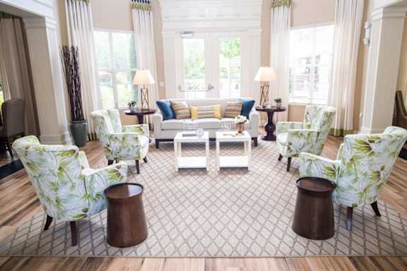 A large room with a blue couch and a chandelier. at Northlake Park Apartments, Orlando, FL, 32827