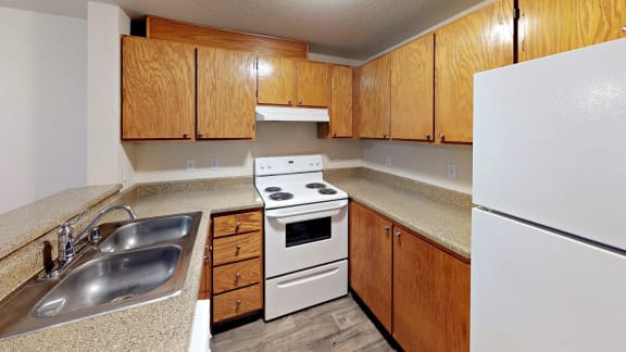 a kitchen with white appliances and wooden cabinets