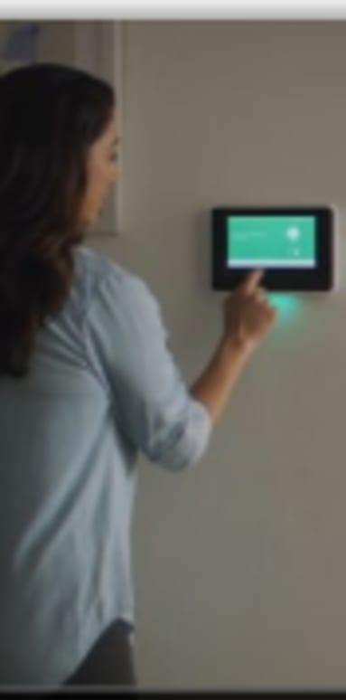 a woman is holding a cell phone in front of a wall