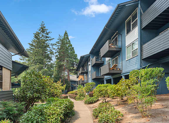 A pathway leads through a landscaped courtyard between two buildings.
