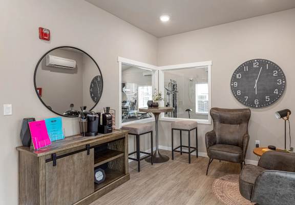 A living room with a brown leather chair and a round mirror on the wall.