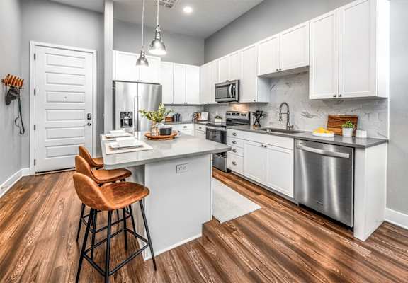 a kitchen with white cabinets and stainless steel appliances