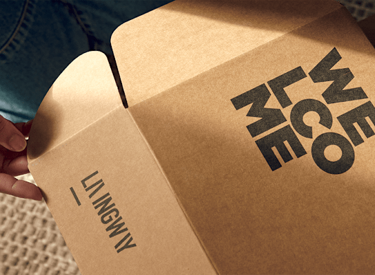 A person is opening a cardboard box with the text "WE LOVE YOU" printed on it.