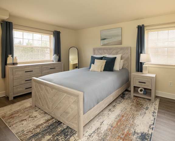A bedroom with a large bed, nightstands, and a rug at Security Park Apartments*, Maryland, 21244