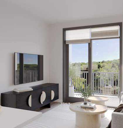 A modern living room with a flat screen TV, a white sofa, and a large window with a view of the outdoors.