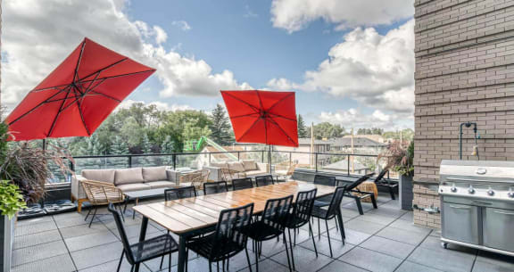 a rooftop patio with tables and chairs and umbrellas at Southpark on Whyte, Edmonton