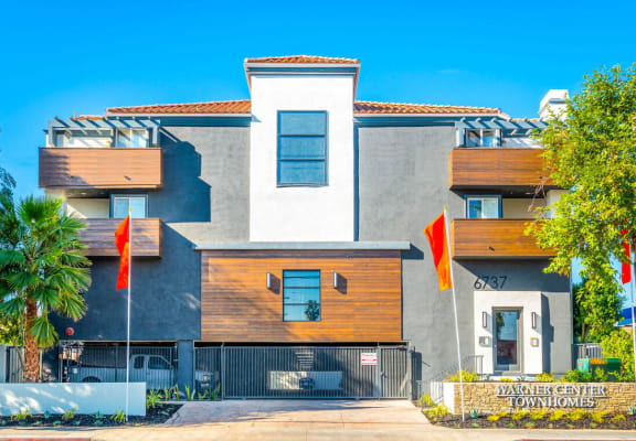 a house with two orange flags in front of it at Warner Center Townhomes, Canoga Park