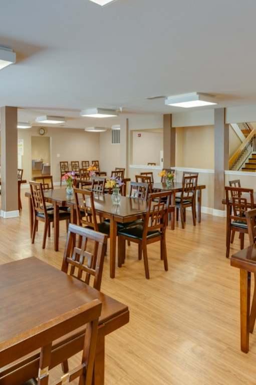 a large dining room with tables and chairs and a kitchen